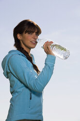 Junge Frau trinkt aus einer Wasserflasche - WESTF02543