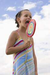 Girl (7-9) holding big lollipop - LDF00333