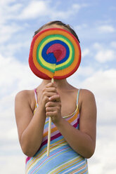 Girl (7-9) holding lollipop in front of face - LDF00330