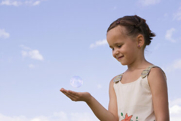 Girl (7-9) holding hand under soap bubble - LDF00325