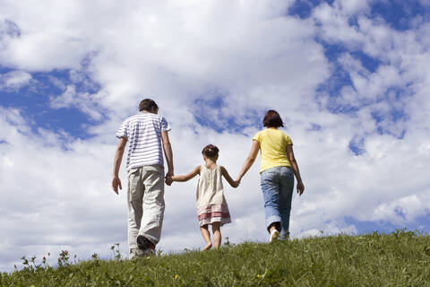 Eltern mit Tochter, Hand in Hand, Rückansicht, lizenzfreies Stockfoto