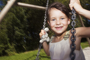 Girl (7-9) sitting on swing, smiling - LDF00298