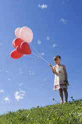 Girl (7-9) holding bunch of ballons - LDF00296