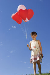 Girl (7-9) holding bunch of ballons - LDF00295