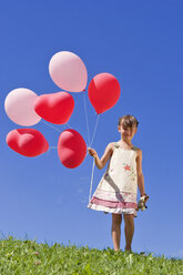 Girl (7-9) holding bunch of ballons - LDF00294