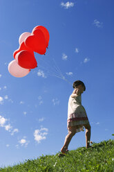 Girl (7-9) holding bunch of ballons - LDF00291