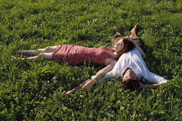 Woman lying with head on man`s belly in meadow - LDF00249