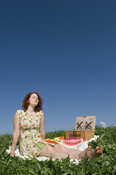 Junge Frau auf Picknickdecke sitzend, Augen geschlossen - LDF00213