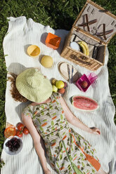 Young woman lying on picnic blanket, overhead view - LDF00207