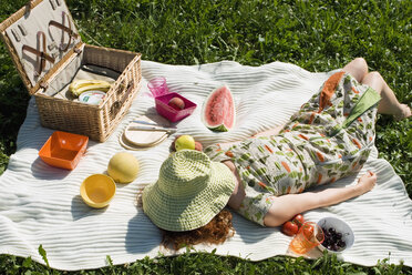 Young woman lying on picnic blanket, elevated view - LDF00205