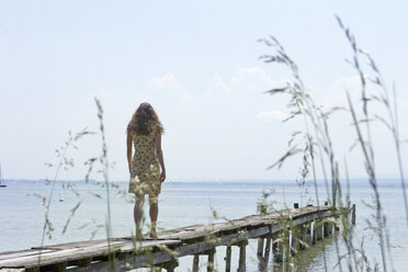 Young woman walking on jetty, rear view - CLF00279