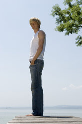 Young man standing on jetty, side view - CLF00270