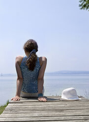 Young woman sitting on jetty - CLF00259