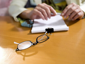 Brille auf dem Schreibtisch liegend - WESTF02837