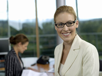 Businesswomen in office, smiling - WESTF02817