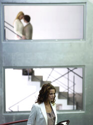 Mittlere erwachsene Frau, die ein Tagebuch hält, Paar, das sich auf einer Treppe umarmt (Fokus auf den Vordergrund) - WESTF02800