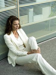 Businesswomn sitting on floor, portrait - WESTF02758