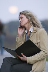 Geschäftsfrau mit Mobiltelefon und Dokumenten in der Hand - WESTF03073