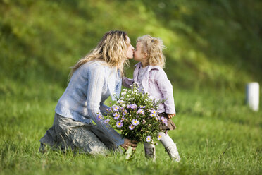 Mutter küsst Tochter, hält Blumenstrauß, Seitenansicht - WESTF03006
