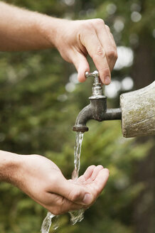 Hände, die Wasser aus einem Brunnen schöpfen, Nahaufnahme - BABF00217