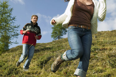 Junges Paar beim Laufen in den Bergen - BABF00188