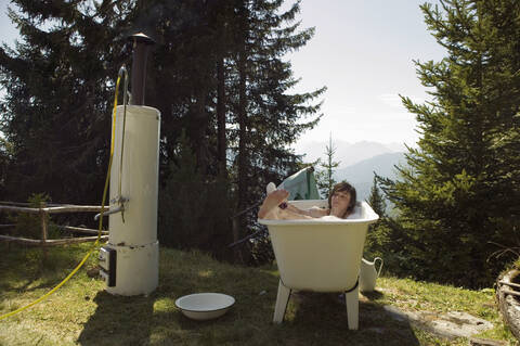 Junge Frau in der Badewanne am Herd liegend, lizenzfreies Stockfoto