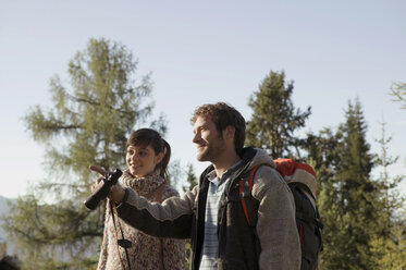 Junges Paar beim Wandern in den Bergen, Mann hält Fernglas - BABF00090