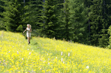 Young woman walking in field - HHF00776