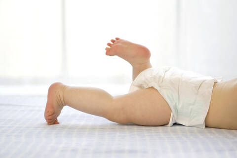 Kleiner Junge (6-12 Monate) auf dem Bauch liegend, Tiefschnitt, lizenzfreies Stockfoto