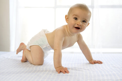 Kleiner Junge (6-12 Monate) krabbelnd, lachend, Seitenansicht - SMOF00015