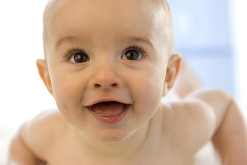 Baby boy ( 6-12 months) lying on belly, smiling - SMOF00003