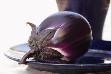 Single eggplant on plate, close-up - ASF02649