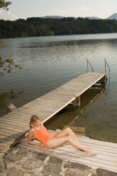 Woman relaxing on jetty - ABF00082