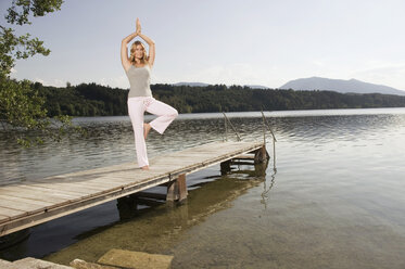 Frau übt Yoga auf dem Steg - ABF00079