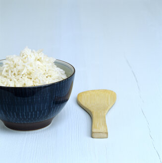 Cooked rice in a dish, wooden spoon aside - COF00043