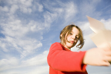 Girl (7-9) holding paper plane, blurred motion - RDF00214