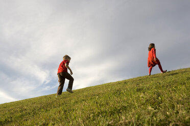 Junge (10-12) und Mädchen (7-9) laufen auf einer Wiese - RDF00206