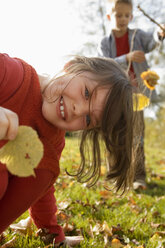 Girl (6-9) holding leaf boy (10-13) in background - RDF00181