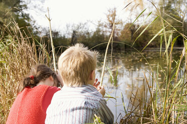 Boy (10-12) and girl (7-9) fishing, rear view - RDF00178