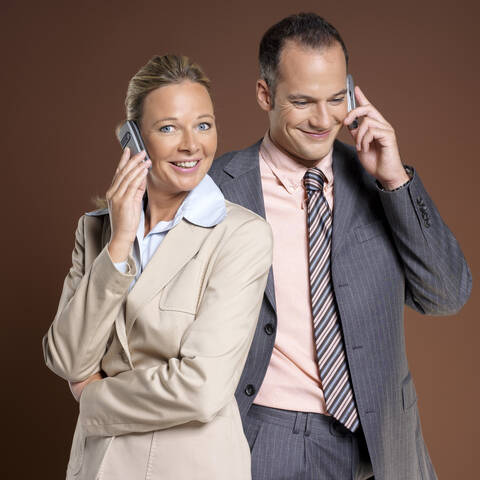 Businessman and businesswoman using mobile phone stock photo