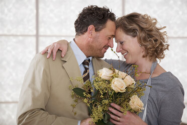 Mature couple in kitchen with flower bouquet - WESTF03310