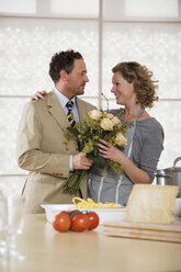 Älteres Paar in der Küche mit Blumenstrauß - WESTF03309