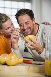Älteres Paar isst Grapefruit in der Küche, lächelnd, Nahaufnahme - WESTF03305