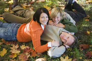 Parents with son (10-12) lying in meadow, portrait, elevated view - WESTF03103