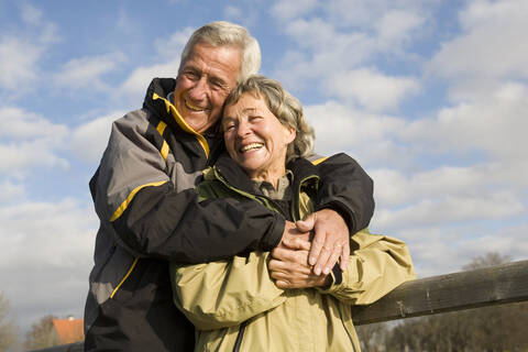 Älteres Paar, Mann umarmt Frau, lizenzfreies Stockfoto