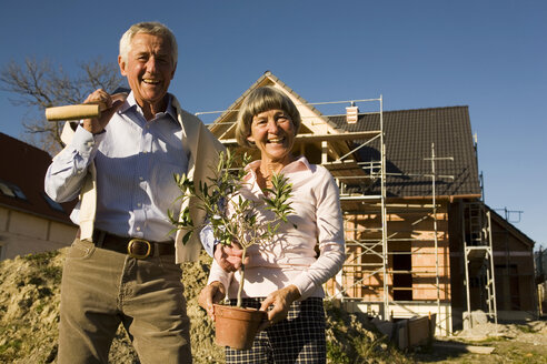 Älteres Ehepaar vor einem teilweise gebauten Haus - WESTF03458