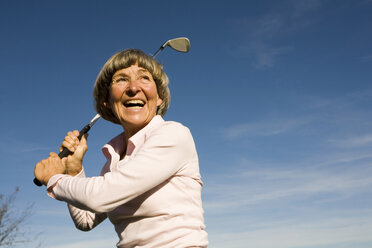 Ältere erwachsene Frau hält Golfschläger - WESTF03441