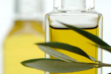 Bottle of olive oil with twig, close-up - ASF02891