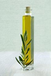 Bottle of olive oil with twig, close-up - ASF02889