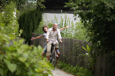 Couple riding bicycle, smiling - HHF00882